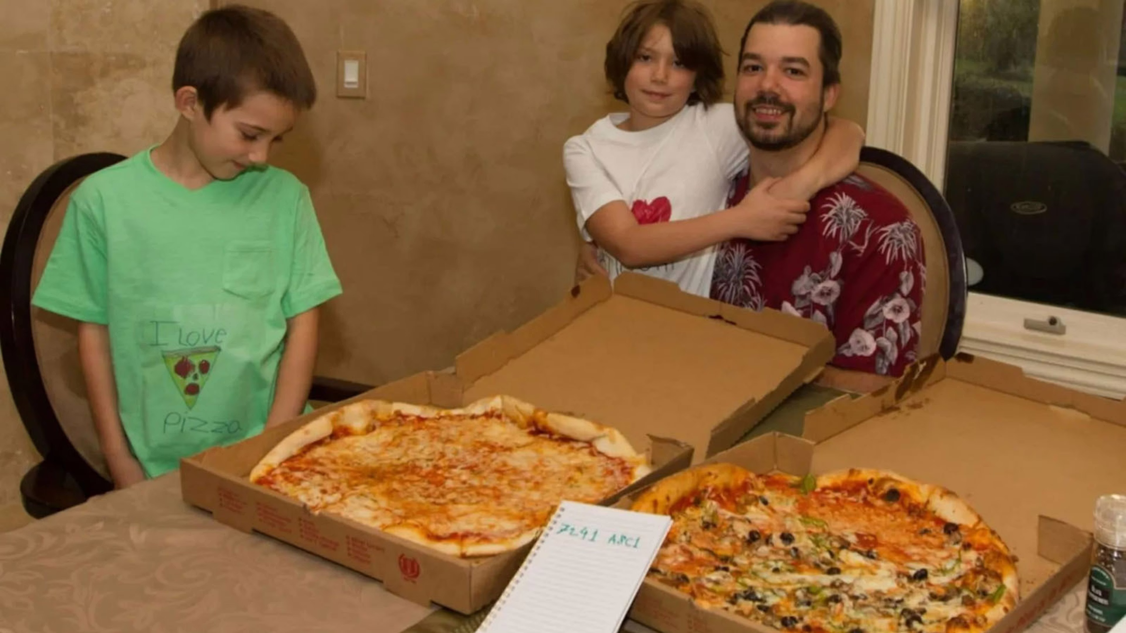 Laszlo Hanyecz with his sons and the two pizzas, photographed in his Florida home.